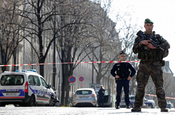 Police and a soldier block the access to the International Monetary Fund (IMF) offices where an envelope exploded in Paris