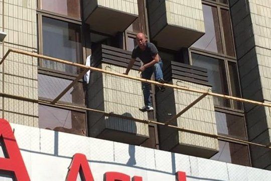 Чоловік, який погрожував викинутися з готелю Хрещатик, заліз у вікно Чоловік на сітці