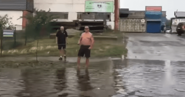 Дощові рибалки: у Києві чоловіки ловили рибу прямо на дорозі
