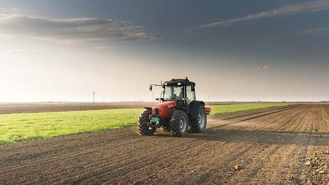 Трактор удобрює землю