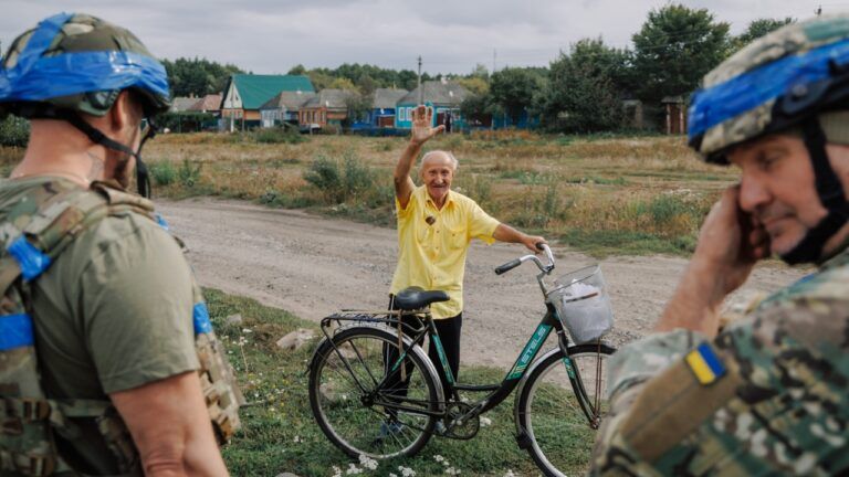 дід махає рукою перед військовими ЗСУ у Суджі